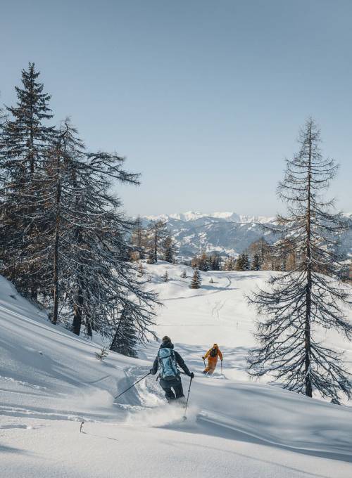 Ein Paar beim Tiefschneefahren abseits der Piste im Snow Space Salzburg