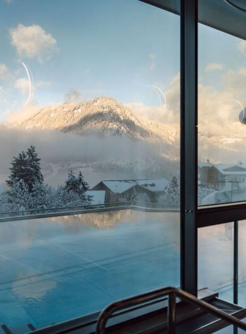 Der Ausblick auf die Berglandschaft vom Infinity-Rooftop Pool im Winter.