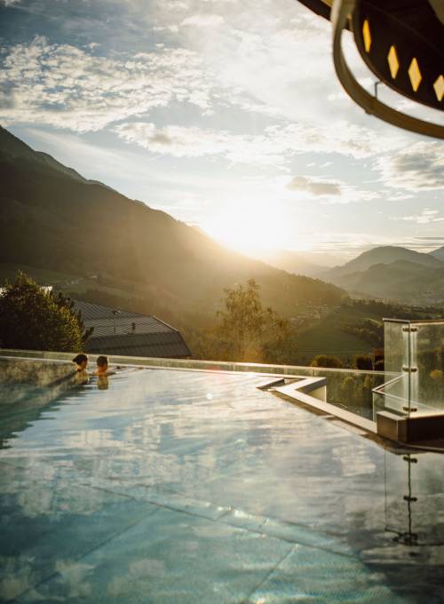 Der Ausblick auf die Berglandschaft vom Infinity-Rooftop Pool im Herbst.